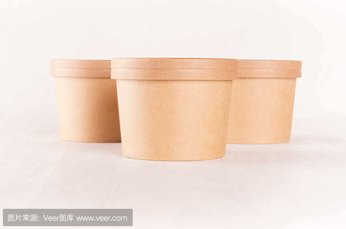 三组空白一次性棕色纸盒外卖食物与帽-汤,沙拉,冰淇淋在白色木架上特写。