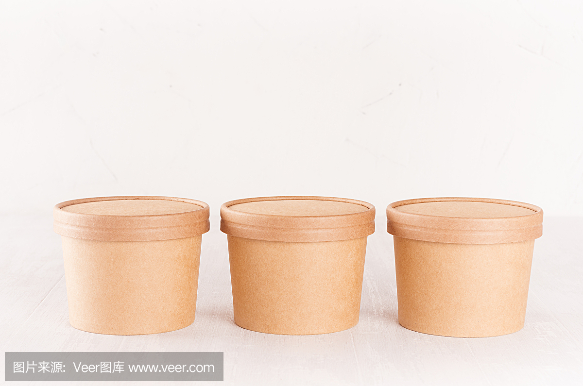 一套三纸板碗与帽子的快餐,汤或冰淇淋在白色木桌上,食品品牌身份模型轻现代风格。